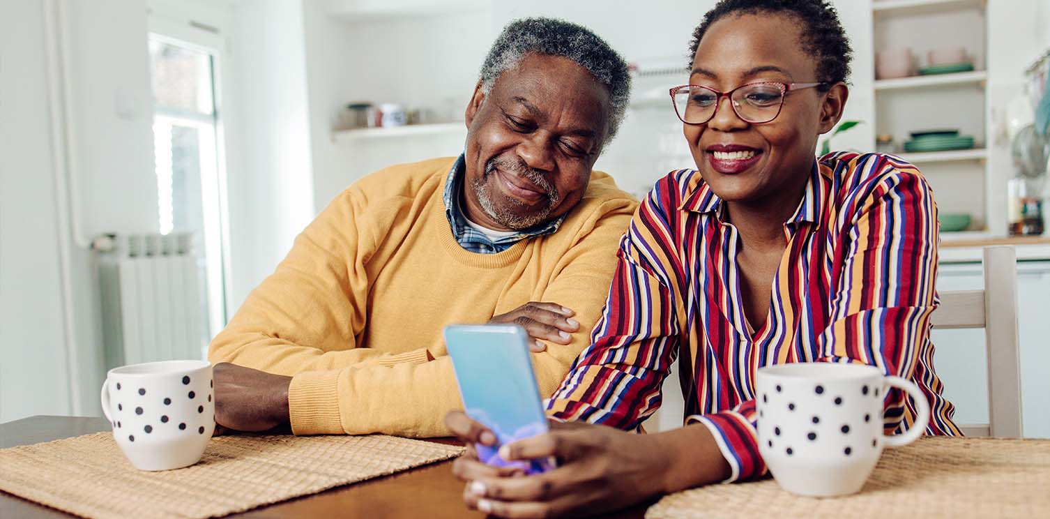 Older black man and woman looking at her smart phone