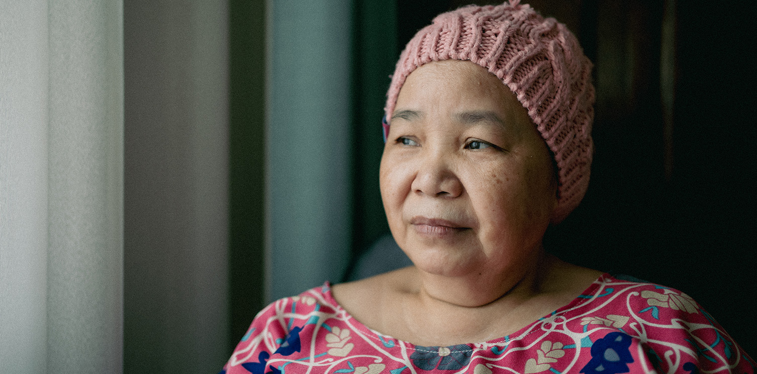older brown-skinned lady in a pink knitted winter cap