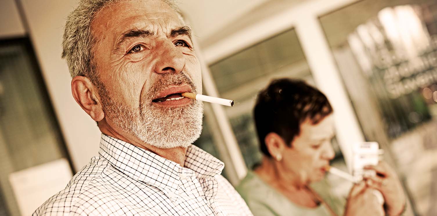 Older man with beard and cigarette hanging from his mouth